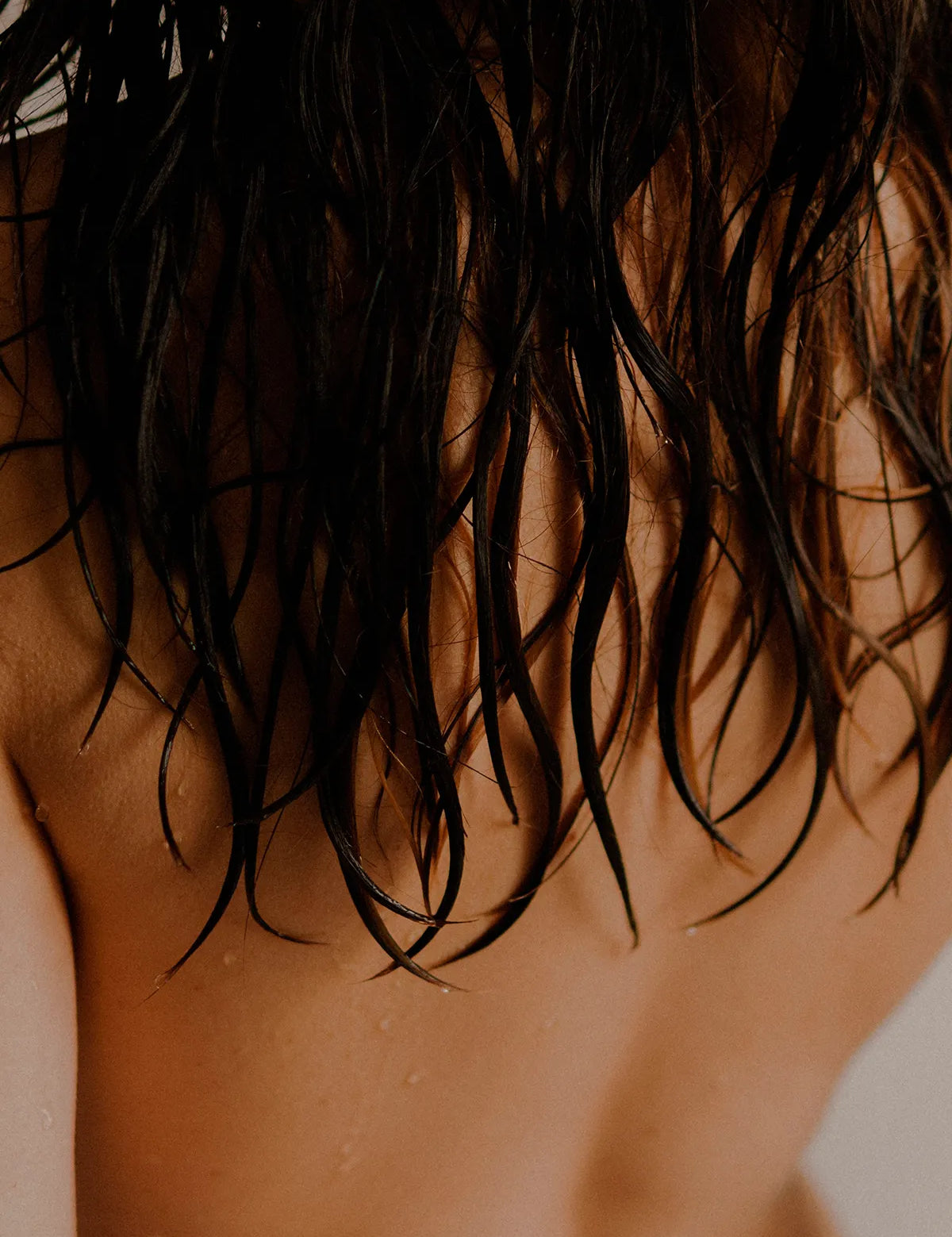 Cannabinoides y salud capilar en foto con chica espalda al aire y pelo mojado