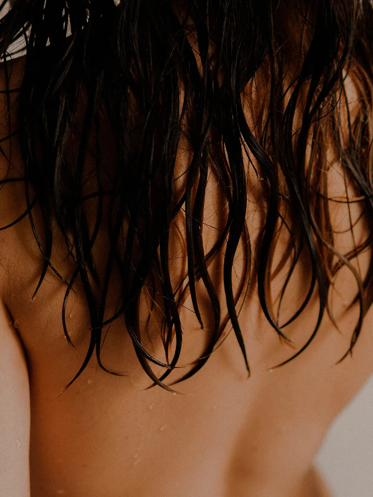 Cannabinoides y salud capilar en foto con chica espalda al aire y pelo mojado